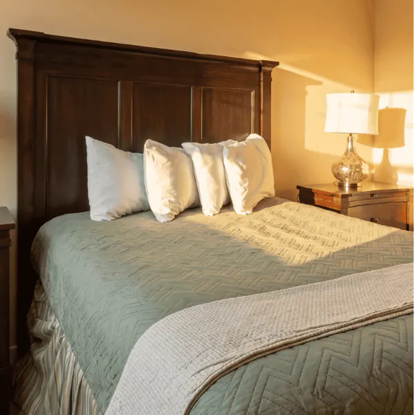 A king bed in a standard room, made up with a quilted throw
