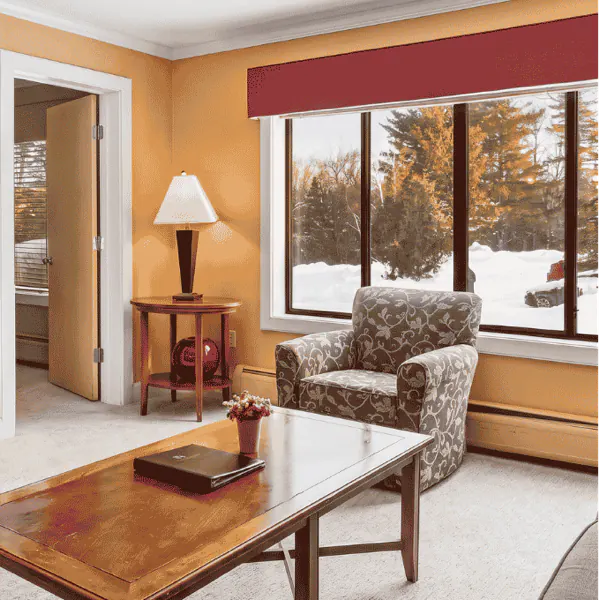 The sitting room of a queen suite, with an armchair by the snowy window